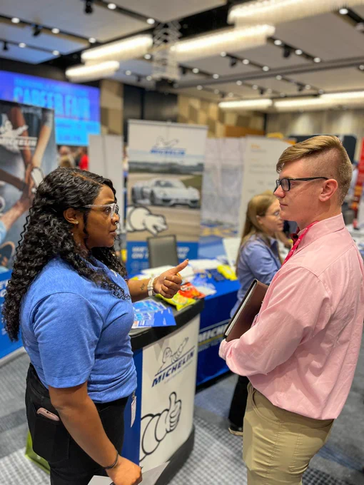 Michelin representative talking to students at engineering and computer science career fair.
