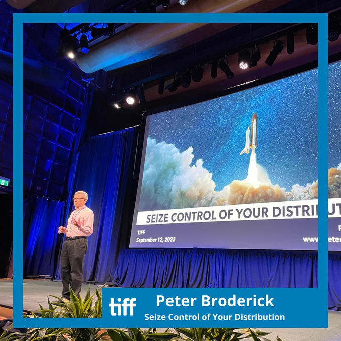 Peter Broderick leading a session called Seize Control of Your Distribution, with a slide projected behind him displaying a rocketship taking off.