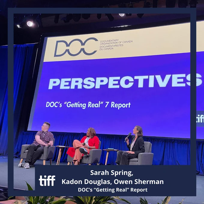 Sarah Spring, Kadon Douglas, and Owen Sherman sitting in grey chairs on stage for a panel discussion called DOC's Getting Real 7 Report.