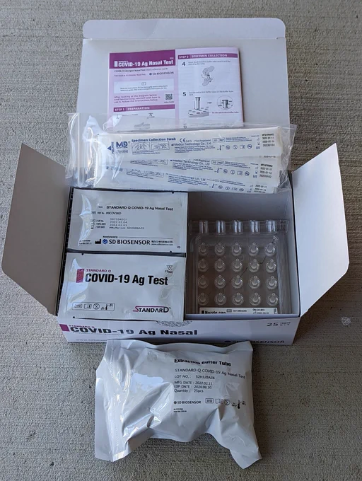An open box of SD Biosensor COVID test kit containing 25 RATs. The expiry date reads August 2024