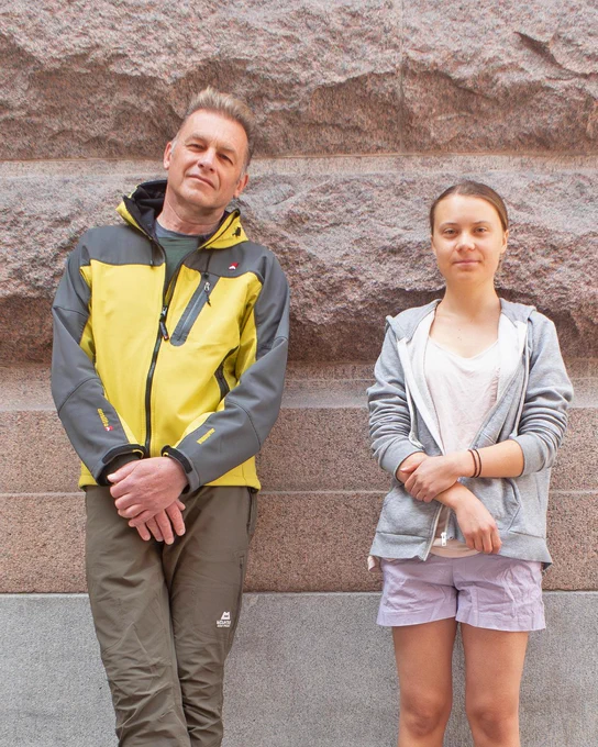 Chris Packham and Greta Thunberg stand leaning against a wall looking at the camera.