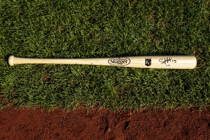 A Salvador Perez signed bat laying in the grass at Kauffman Stadium. (Photo by Jason Hanna/Kansas City Royals)