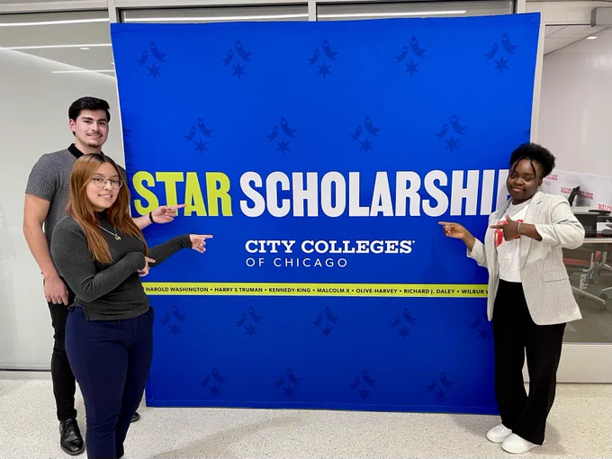 Students point to a large sign that reads "Star Scholarship."