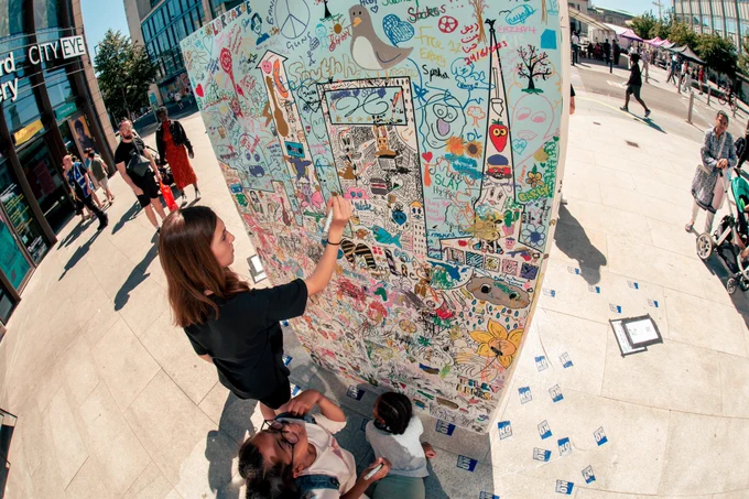 Young people colouring in mural at What's Next Southampton? festival in Guildhall Square Southampton. 