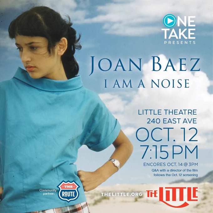 Joan Baez, a woman in blue, standing with her hand on hip