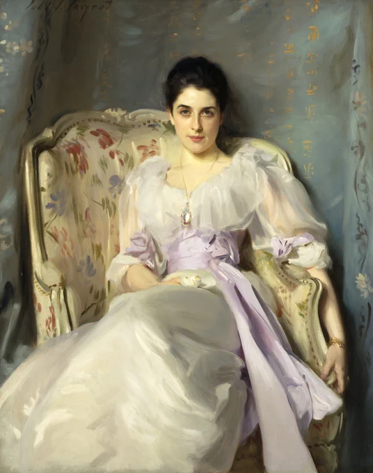 An 1892 portrait of a woman sitting in a chair and wearing a white dress with a lilac bow around the waist