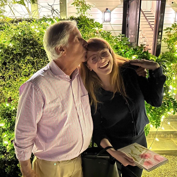 BDH celebrates a dinner at The Winklers. Outside by the bushes, godfather Henry Winkler (left) kisses BDH (right) on the head as they wrap their arms around each other.