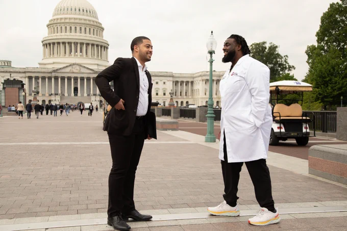 Kylar Wiltz and Russell J. Ledet, MD talking to each other while standing outside in front of Capitol Hill.