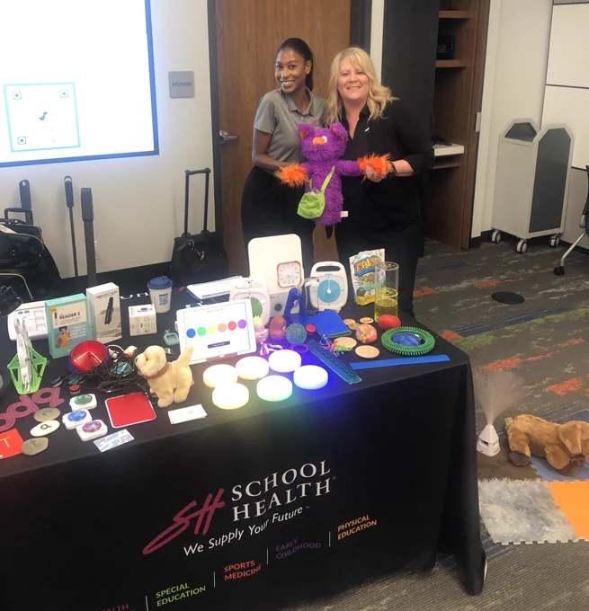 Vada & I with a table full of AssistiveTechnology & Edgar a purple emotion puppet