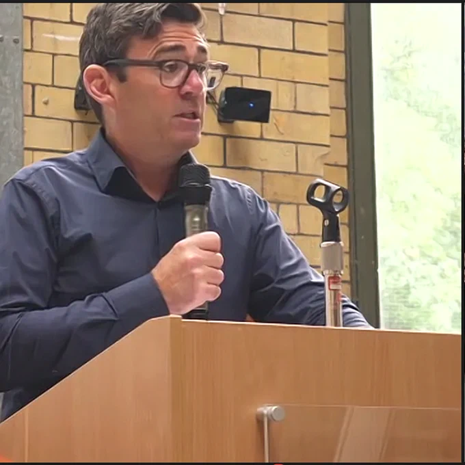 Andy Burnham speaking into a microphone at a conference