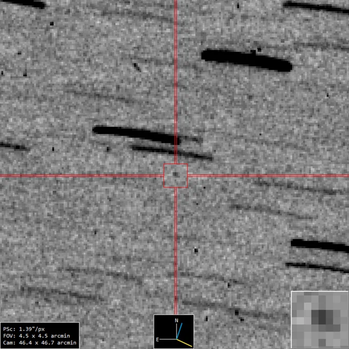 A small, slightly fuzzy black speck is in the centre of a grey image. That speck is NASA's OSIRIS-REx spacecraft, carrying a sample from asteroid Bennu. All around it are long, horizontal lines, slightly bent, some thick and some thin, which are background stars.