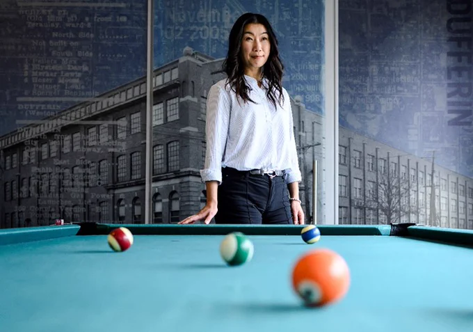 Photo of Linda Hung, new vice president of business development at FORREC, standing behind a pool table.