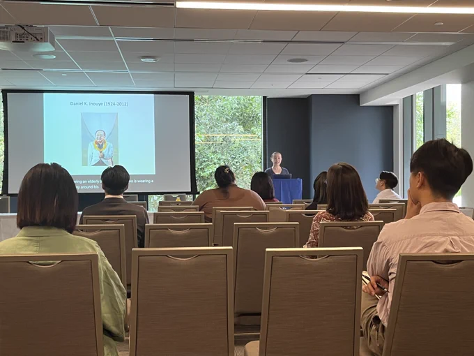 Seated symposium attendees listen to a talk by Cynthia Wu of Indiana University
