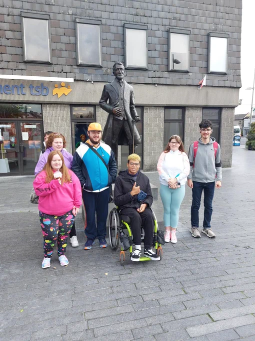 People photographed beside a statue.