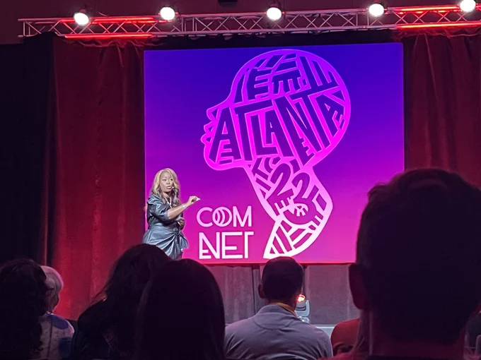 Black Voters Matter co-founder LaTosha Brown on stage with the ComNet Atlanta 23 logo on a screen