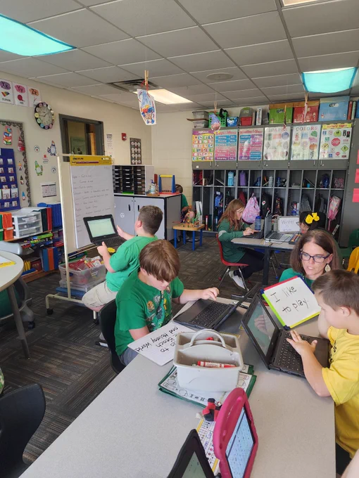 Students using white boards and computers to write. 