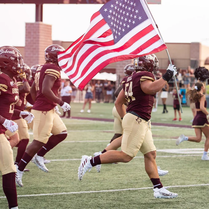Football player holding US flag