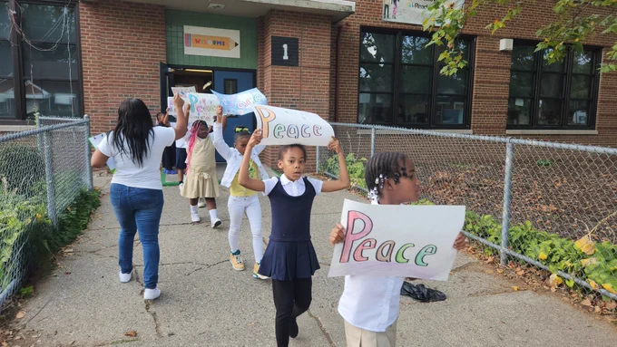 Students with signs march in celebration of world peace day