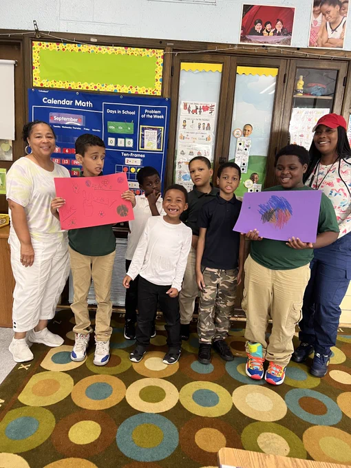 Students and teachers pose with world peace day signs 