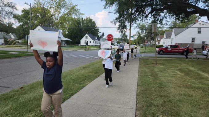 Students with signs march in celebration of world peace day