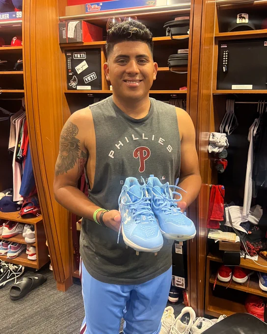 Photo of Ranger Suárez holding a pair of powder blue cleats.