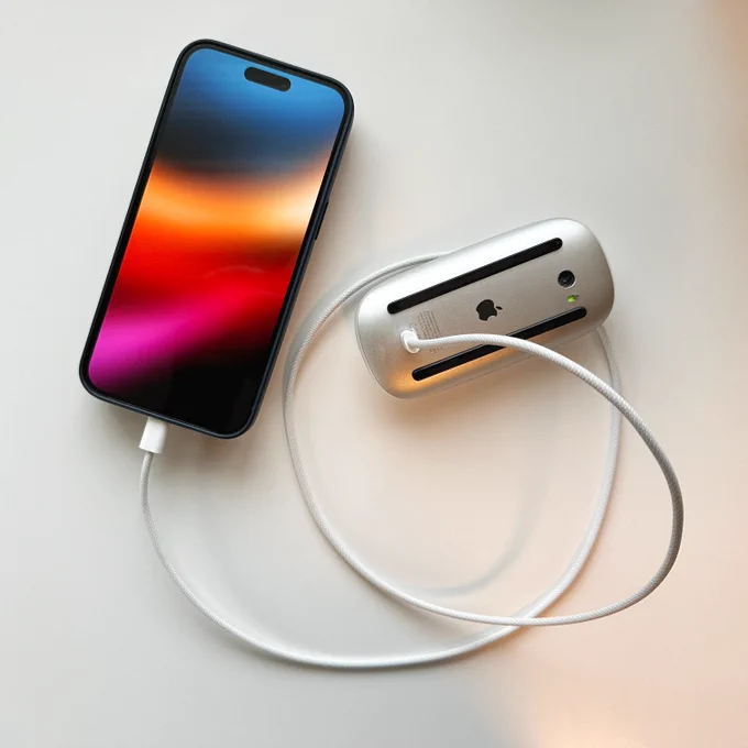 iPhone 15 Pro Max charging the Apple Magic Mouse via USB-C.