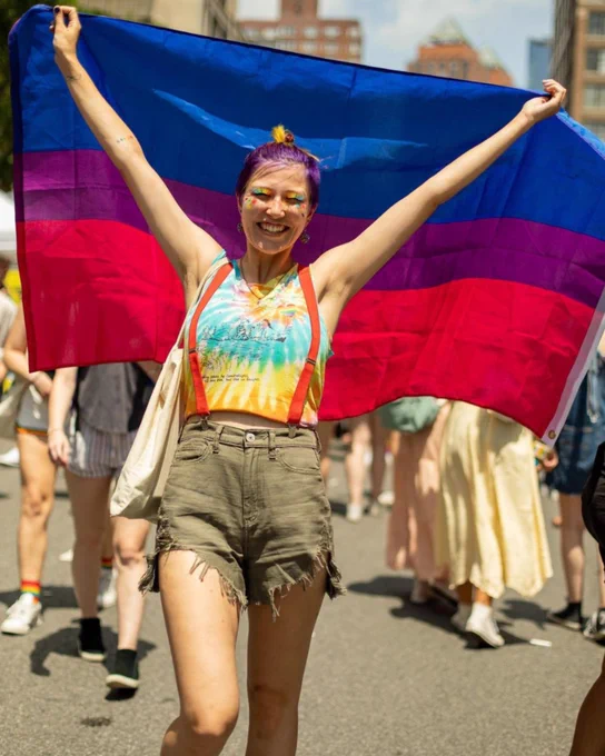 Photo of a person holding the Bi Pride flag