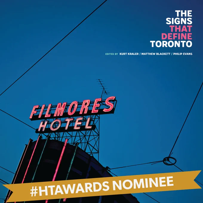 Photo of a dark blue sky with a building in the bottom left that has a red neon sign that says "FILMORES HOTEL". In the top right are the words "THE SIGNS THAT DEFINE TORONTO" "EDITED BY KURT KRALER, MATTHEW BLACKETT, PHILIP EVANS". Text in a gold banner reads: #HTAWARDS NOMINEE