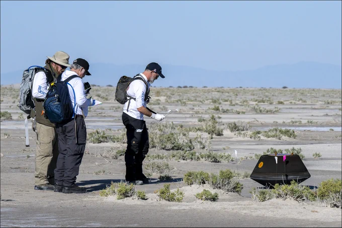 From left to right, NASA Astromaterials Curator Francis McCubbin, NASA Sample Return Capsule Science Lead Scott Sandford, and University of Arizona OSIRIS-REx Principal Investigator Dante Lauretta, collect science data, Sunday, Sept. 24, 2023, shortly after the sample return capsule from NASA’s OSIRIS-REx mission landed at the Department of Defense's Utah Test and Training Range. The sample was collected from the asteroid Bennu in October 2020 by NASA’s OSIRIS-REx spacecraft. Photo Credit: (NASA/Keegan Barber)