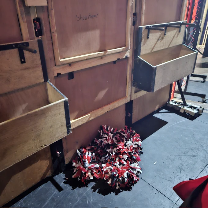 Wooden and a pile of red and black pom poms