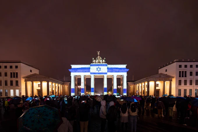 Das Foto zeigt das Brandenburger Tor in Berlin beleuchtet in den Farben der israelischen Flagge. 