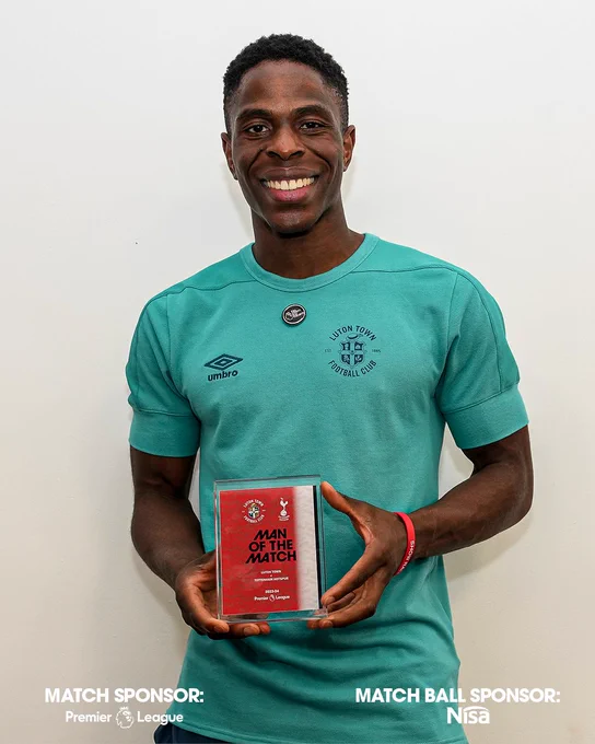 Ogbene holding a man of the match trophy.