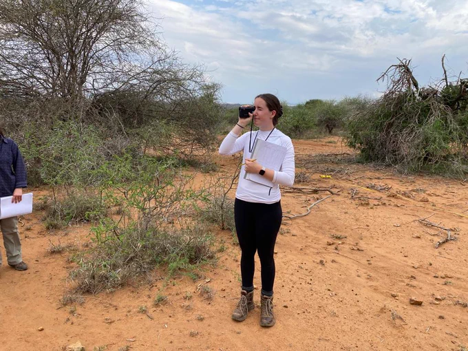 Three female students in the field collecting data for their research projects.