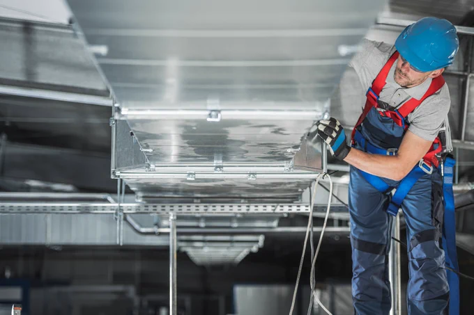 An engineer works on ventilation shafts in an industrial setting