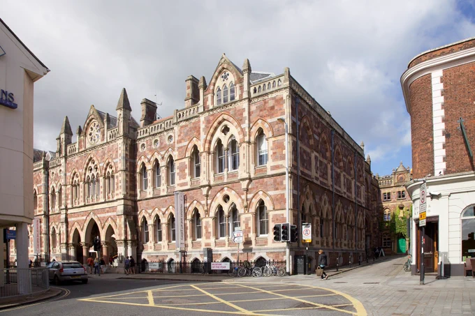 the  exterior of the Royal Albert Memorial Museum, a large Victorian building on Queen St in Exeter, with a blue and white cloud sky above