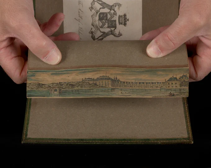 Book fanned to show fore-edge painting of the Chateau de Fontainebleau
