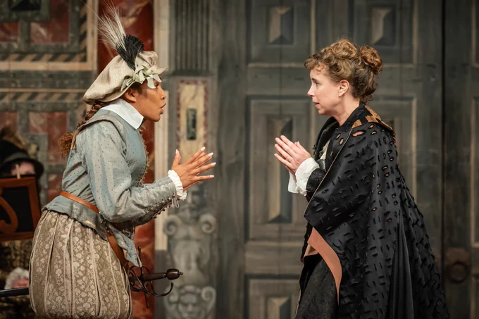 The cast of Twelfth Night: For One Night Only onstage in the Globe Theatre (2023) - two cast members facing each other and talking with their hands up.