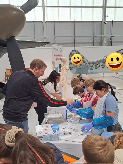 Children wearing nitrile gloves and aprons, using medical equipment.