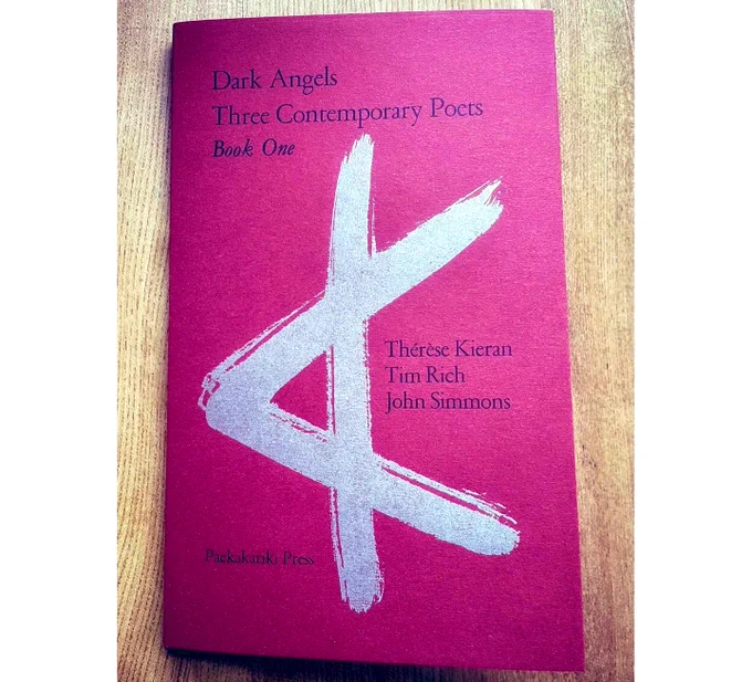 Cover of the book ‘Dark Angels: Three Contemporary Poets’: a deep red with silver aleph symbol, printed letterpress by @paekakarikipress. The book features poems by Thérèse Kieran, John Simmons and Tim Rich