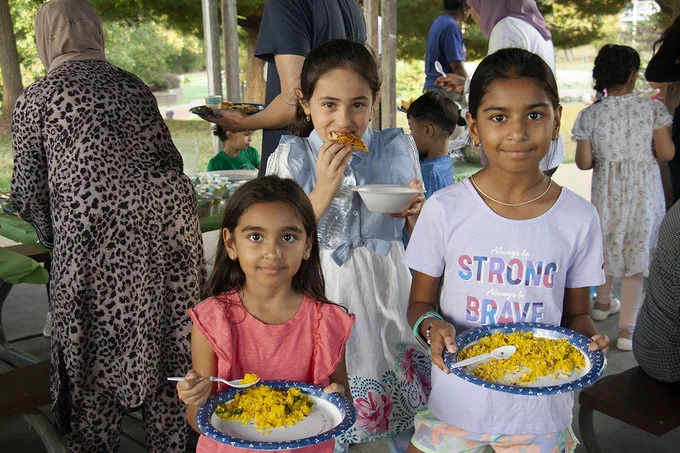 Three Rockwood elementary students smile for a picture before sampling food at Vlasis Park in Ballwin.