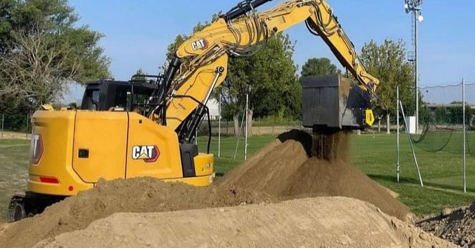 A Crusher attachment manufactured by MB Crusher, installed on a Caterpillar 315, is at work crushing gravel in Italy.