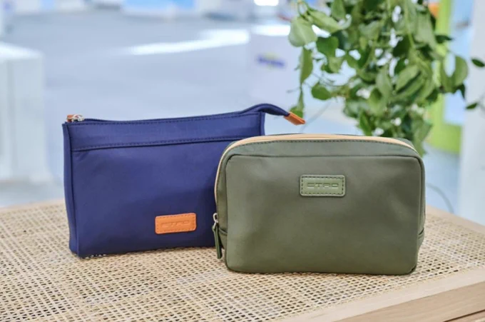 Two sustainable amenity kits from Formia are pictured, one blue and one green. 