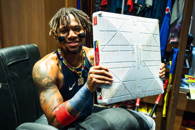 Ronald Acuña Jr. holds up his historical 70th stolen base in the Braves clubhouse