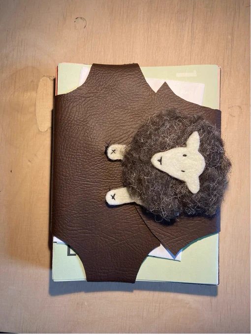Binding depicting a Herdwick sheep surrounding an A5 block of drawings.