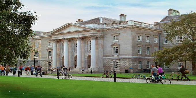 Building in Trinity College Dublin’s Front Square with lawn in foreground and trees on either side.