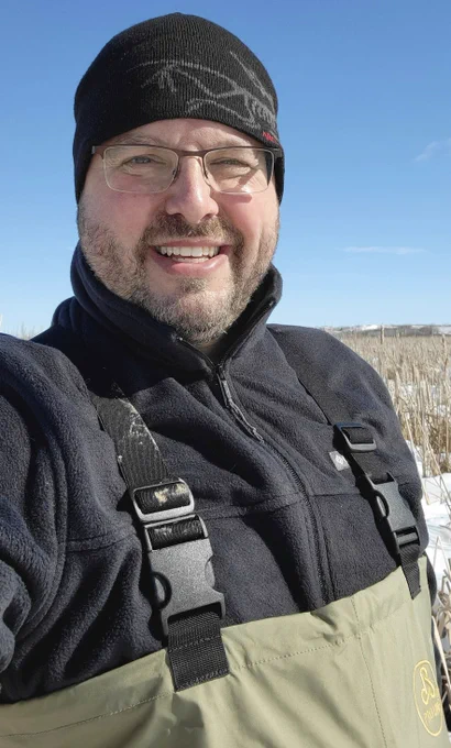 Eric Carson in winter cap and chest-high waders on frozen Cherokee Marsh


