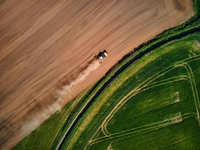 Ariel view of a tractor as it prepares land for growing crops. 