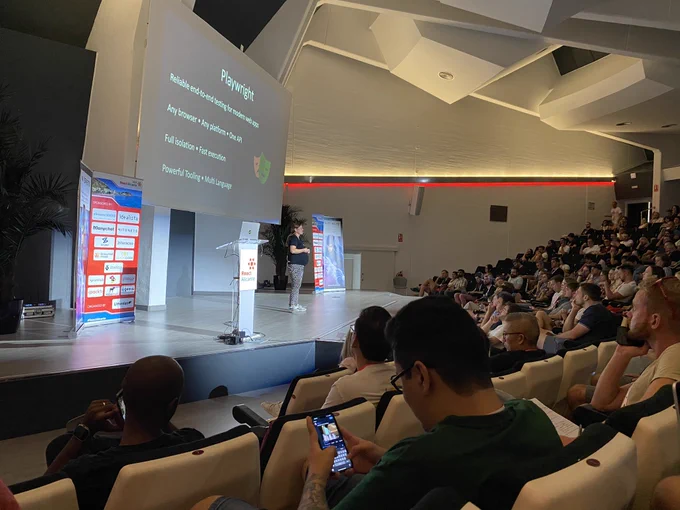 Deb O’Brien (and twins!) onstage at React Alicante presenting in front of a crowd.
