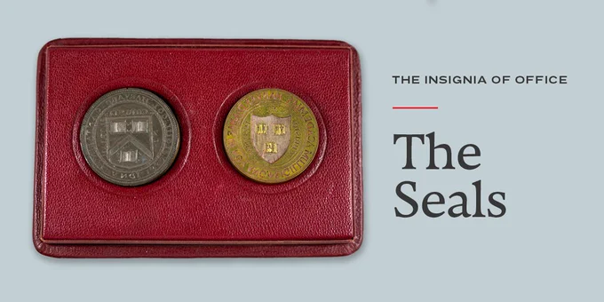 Two tarnished metal circular seals fitted in a red box. Next to the Seals, words read "The Insignia of Office. The Seals" 