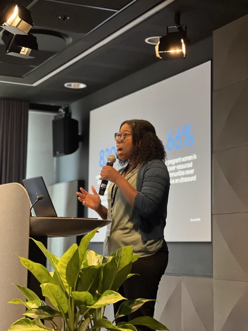 Google Researcher Angelica Willis holding a microphone and speaking at Research@ Accra.